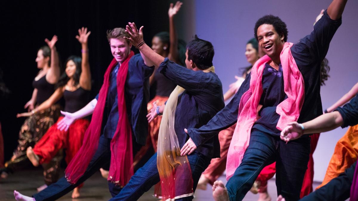 Students participate in Diwali style dance on a stage.